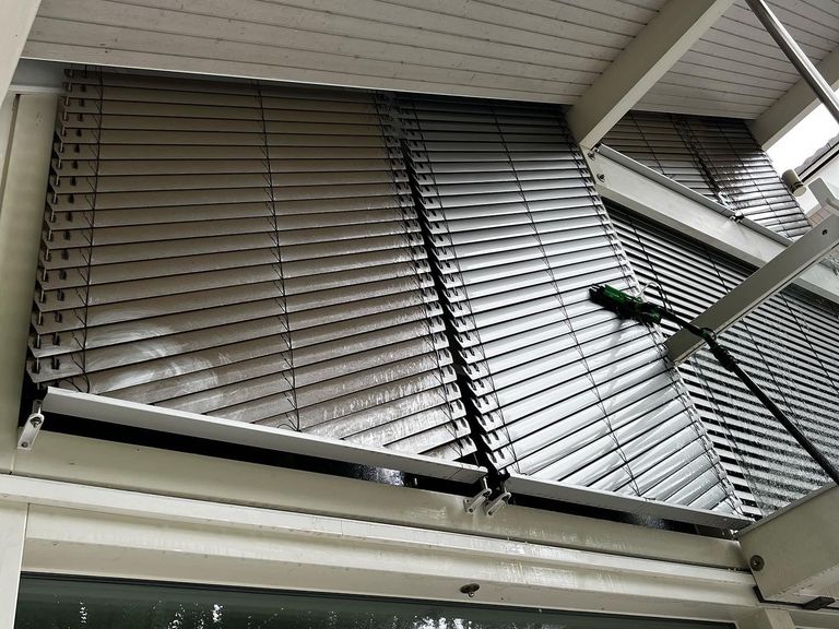 Professionelle Jalousienreinigung an den großen Fensterflächen eines HUF Hauses