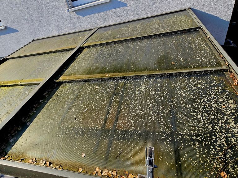 "Stark verschmutzte Terrassenüberdachung vor der Reinigung 