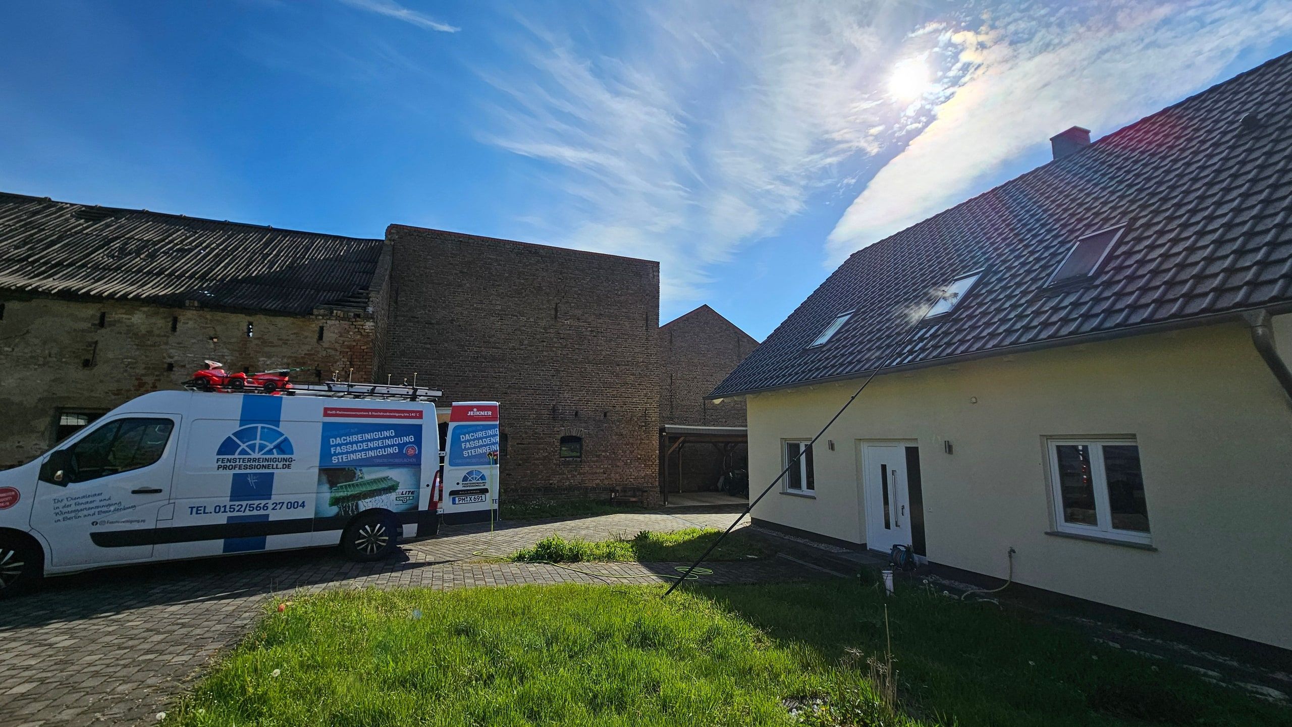 Firmenfahrzeug der Fensterreinigung Professionell im Einsatz vor einem Wohnhaus