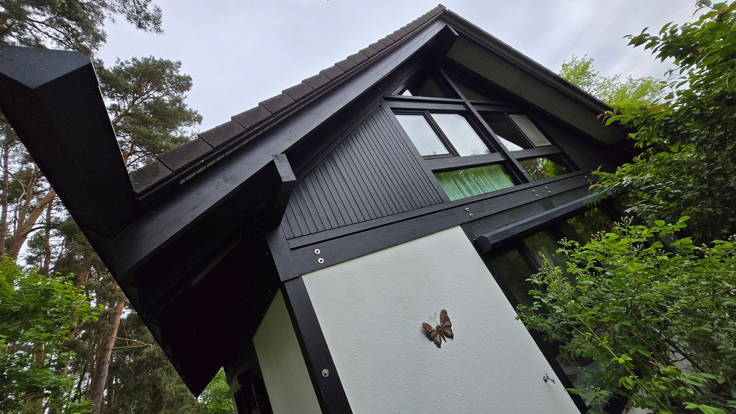 Anthrazitfarbener Hausgiebel mit frisch gereinigtem Dachfenster