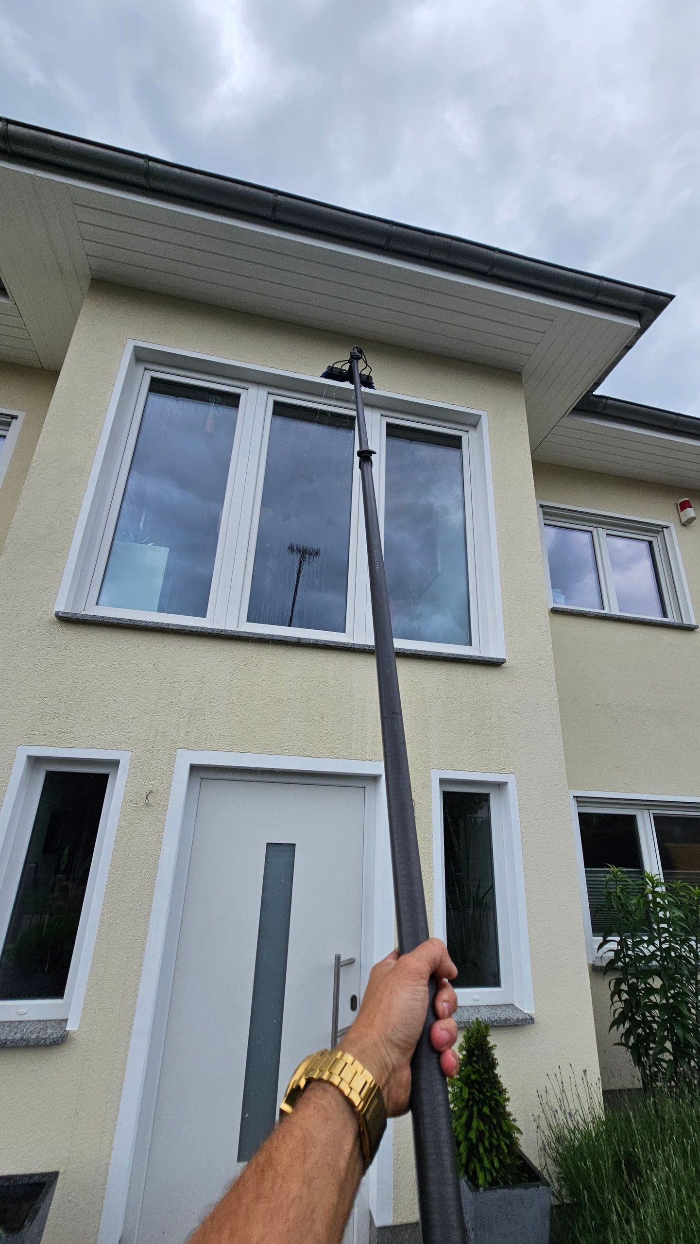 Reinwasserstange vor der hellen Fassade eines Wohnhauses