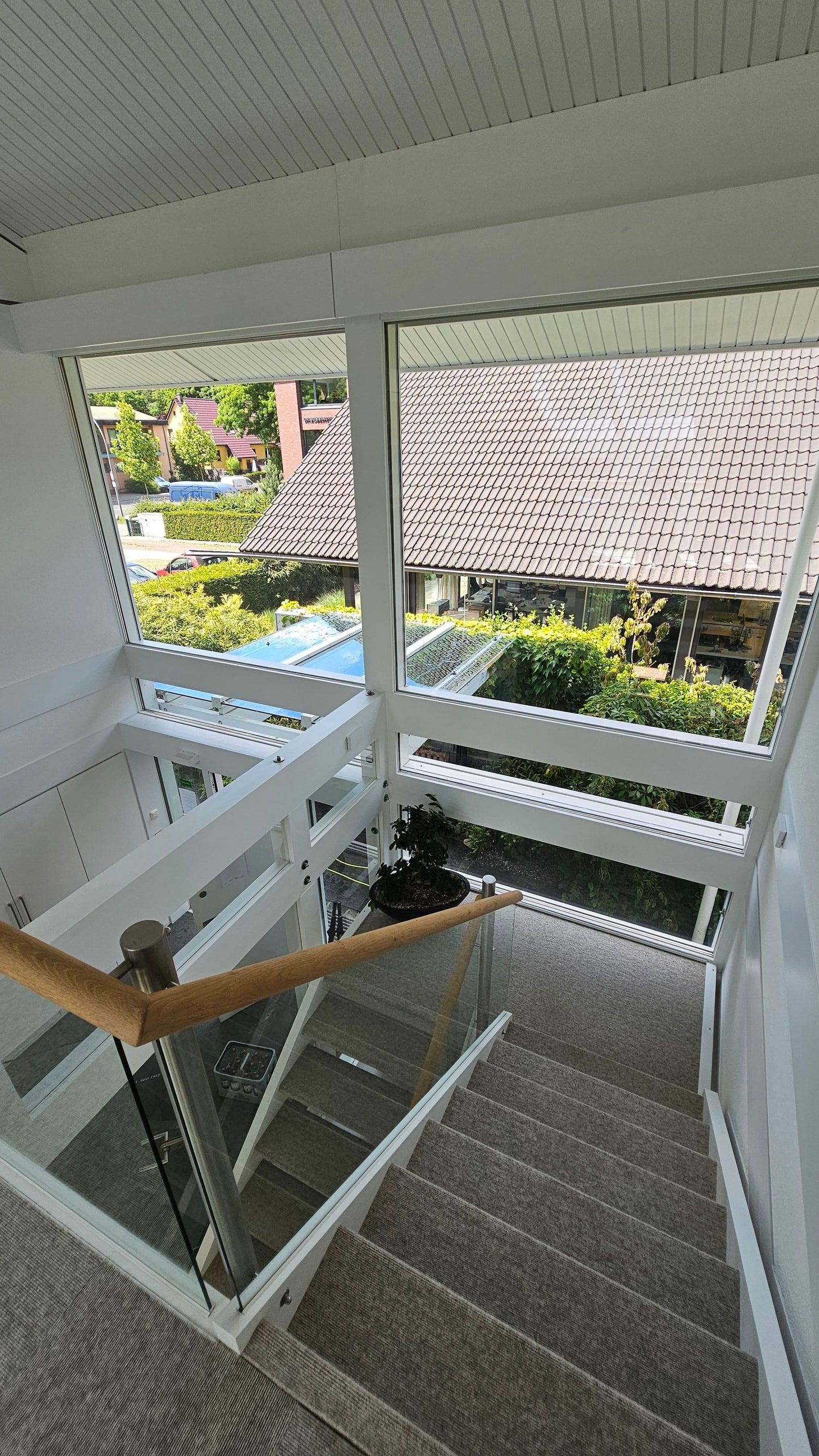 Blick durch die gereinigte Glasfront eines HUF-Hauses vom Treppenpodest