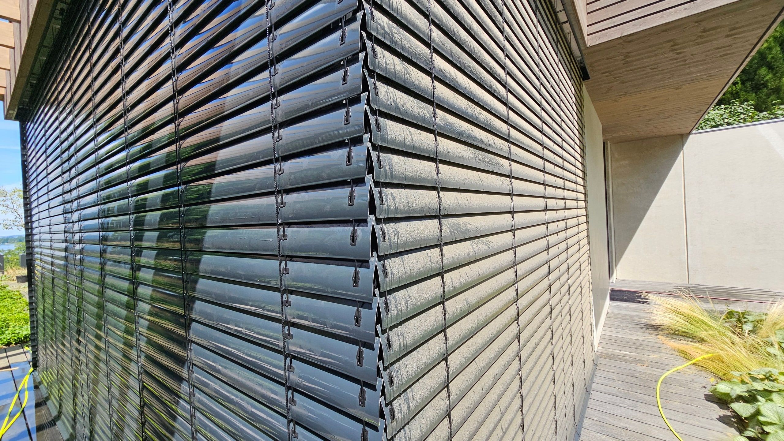 Über Eck geführte Außenjalousie an einer modernen Holzfassade