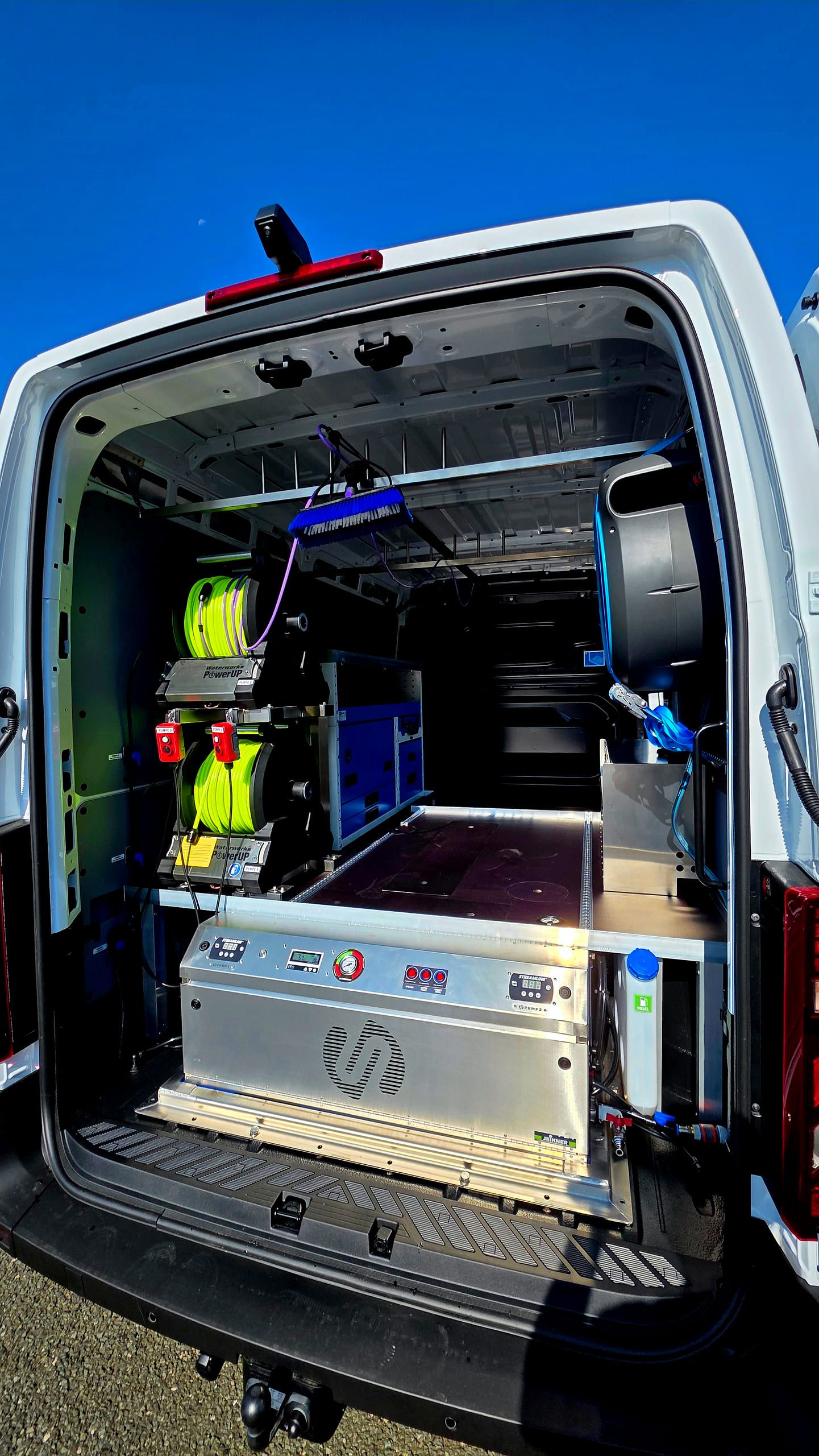 Ausbau im Heck des Elektro-Transporters: zwei Schlauchtrommeln mit gelbem Reinwasserschlauch über dem Streamline-Smartank im Aluminiumrahmen