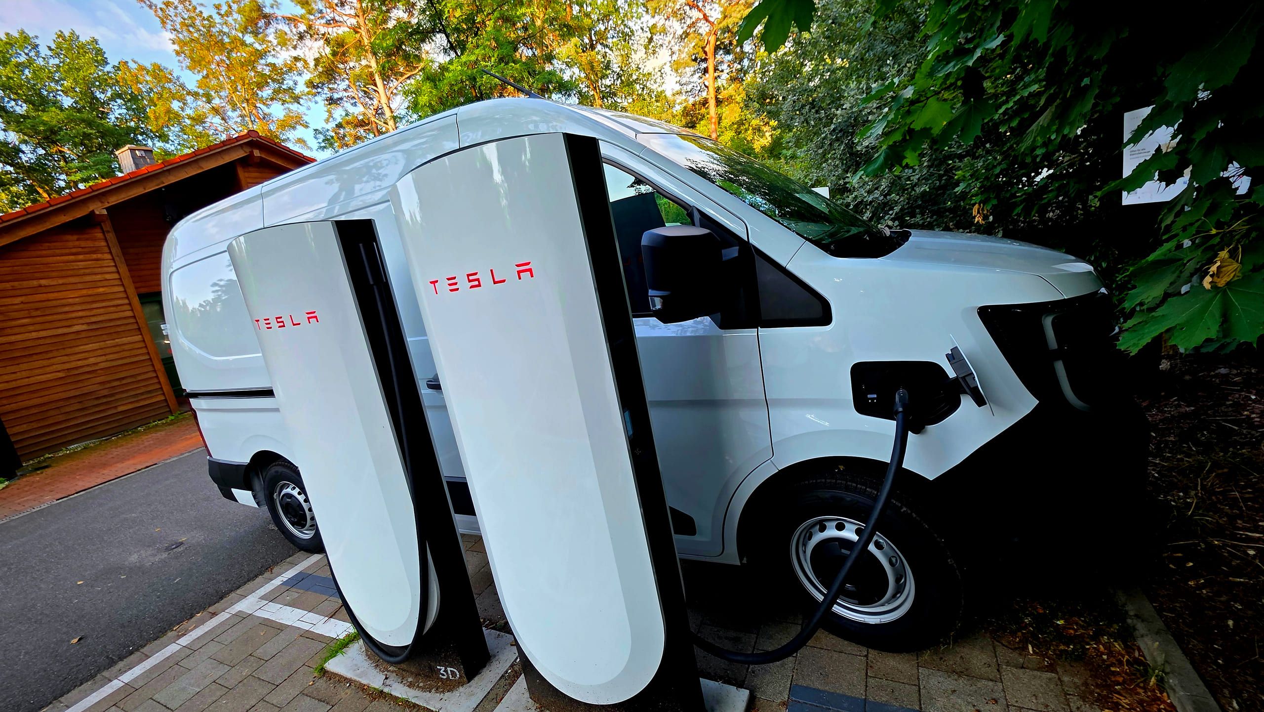 Der Elektro-Transporter lädt an einer Schnellladesäule, das Ladekabel steckt in der Front
